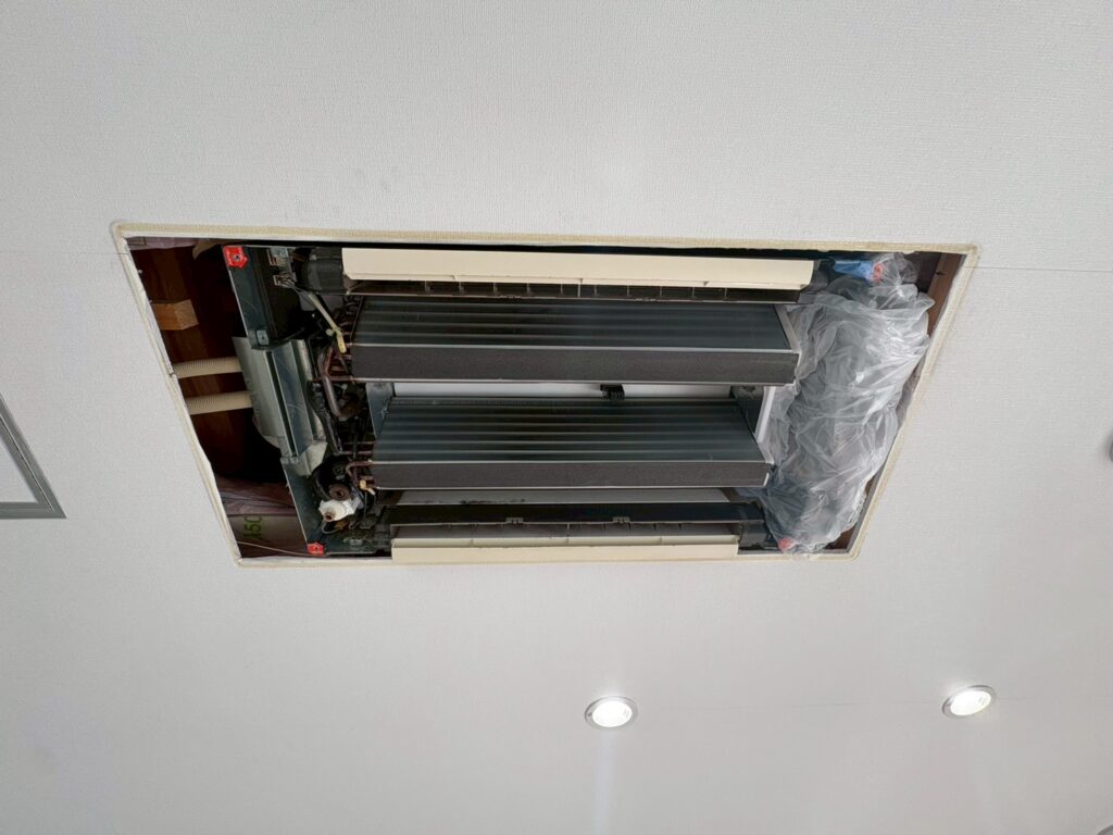 天カセエアコンを分解し内部を点検している様子（宇治市 店舗）